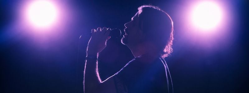 A rock singer in purple lighting.