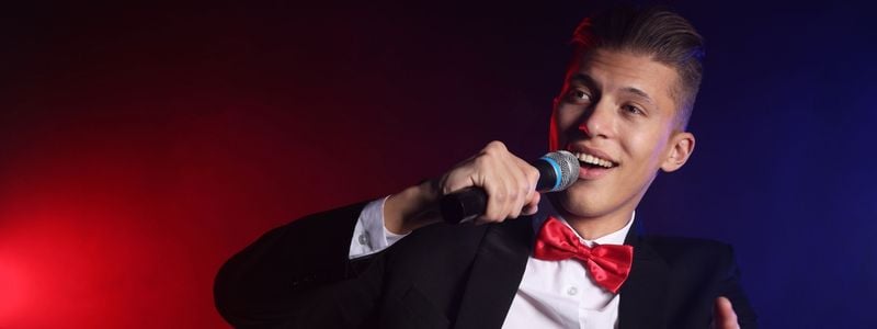 A man in a suit singing into a microphone.