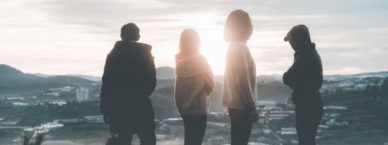 Four young adults on a hill's edge.