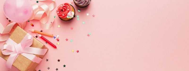 Brown wrapped gifts on a pink background.