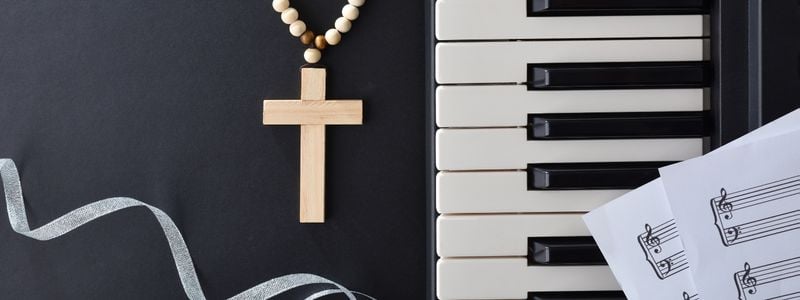 Piano keys, music, and a cross necklace.