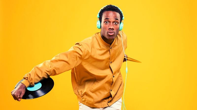 A man with headphones and a record in his hands.