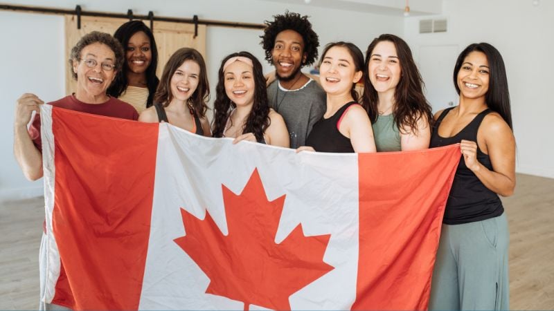 A group of people holding a Canadian flag.