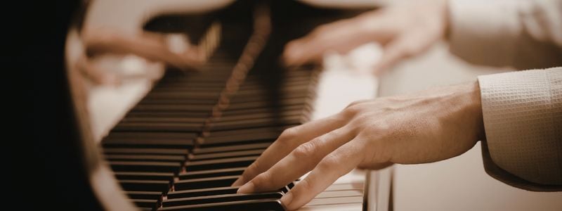 Two hands at the piano.