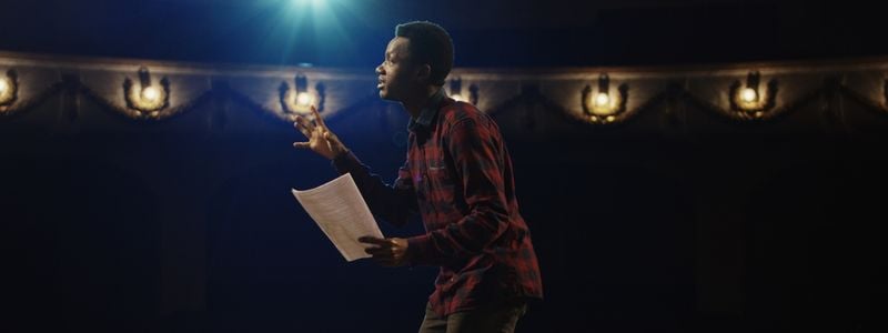 An actor on stage with a script.