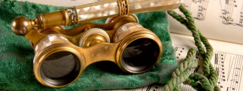 Vintage opera glasses on sheet music.