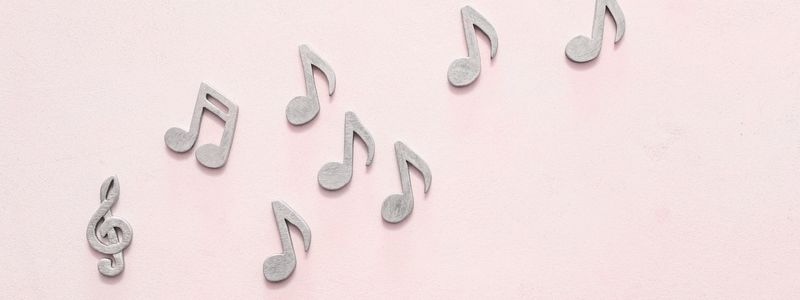 A string of music notes on a light pink background.