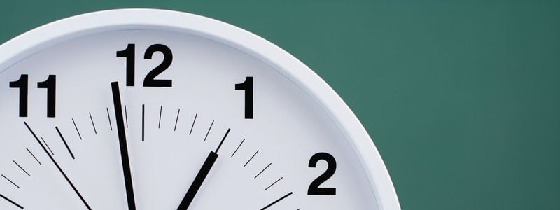 The top of a clock on a green background.