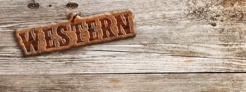 A western sign on a wooden background.