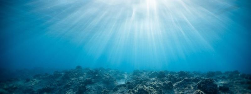The ocean with sunlight shining through.