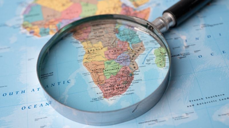 A magnifying glass focused on Africa on a map.