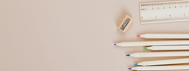 Pencils, sharpener, and a ruler on a beige background.
