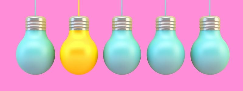 One yellow lightbulb in a row of blue bulbs.