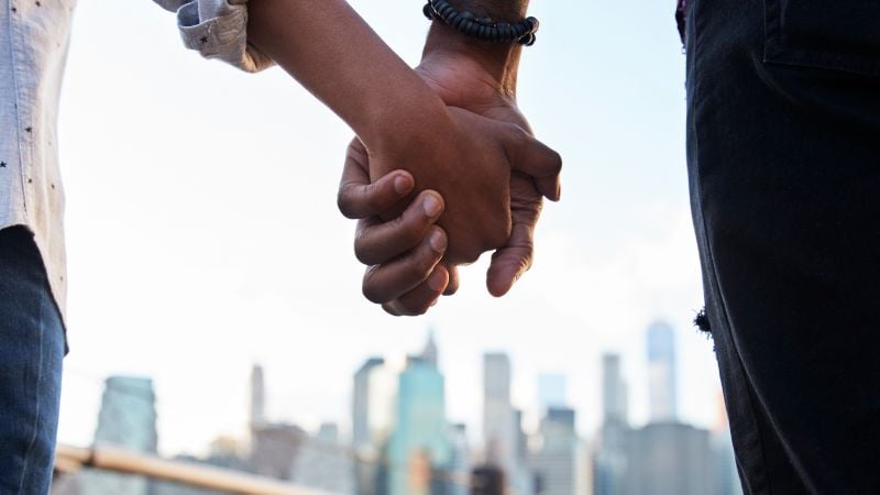 Hand holding with the NYC skyline as a backdrop.