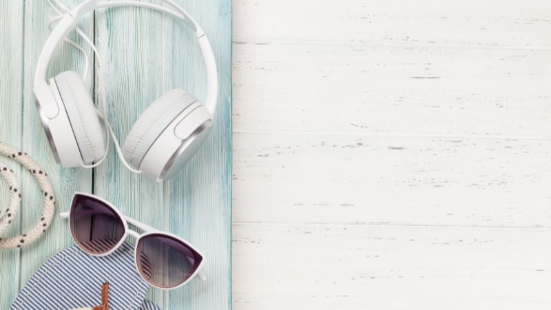 Headphones on a nautical backdrop with sunglasses, rope, and flip flops.