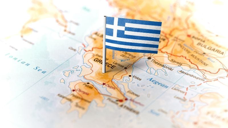 A map of Greece with a Greek flag marking it.