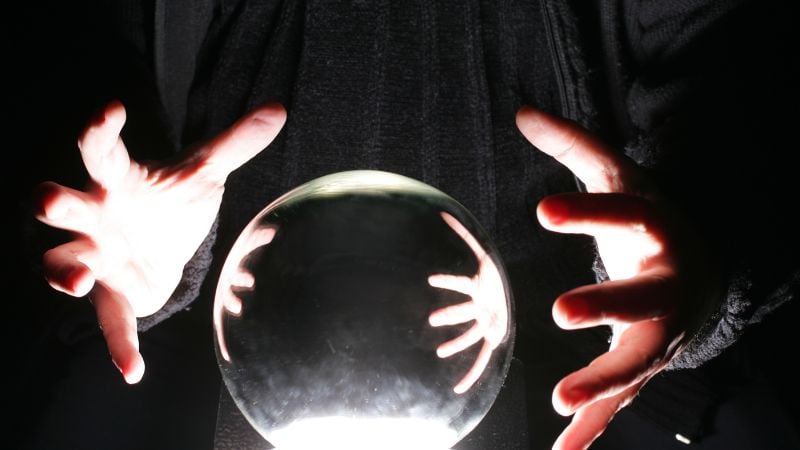 A fortune teller's hands around a crystal ball.