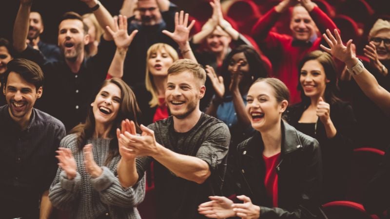 An audience laughing and participating in the show.