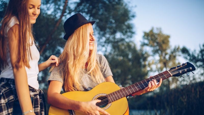 Two friends singing together - one with a guitar.
