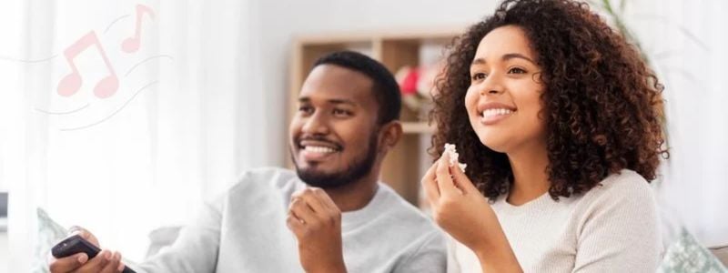 A smiling couple watching TV.