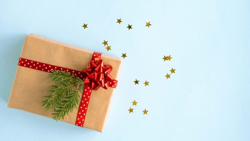 A festive gift surrounded with star confetti.