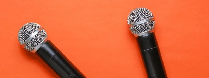 Two microphones with orange background.