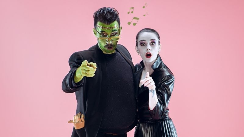 A couple dressed in Halloween costumes and looking at the camera.