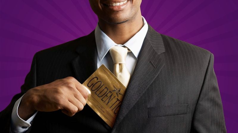 A man pulling out a golden ticket from his coat.