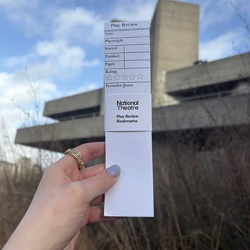 A hand holding play review bookmarks